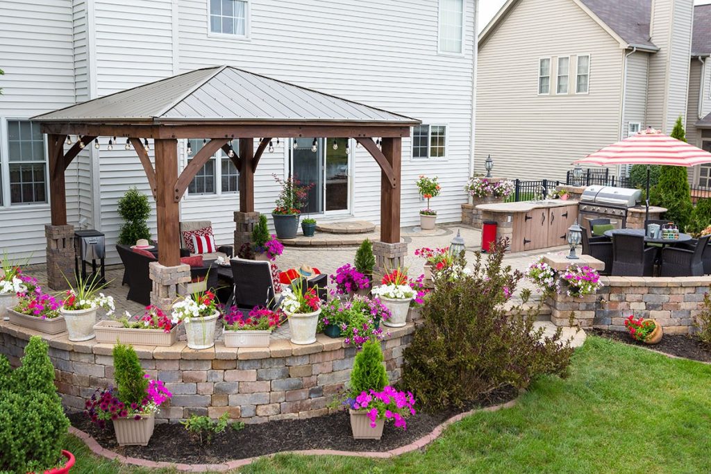 Colorful exterior gazebo in curved patio with summer flowers